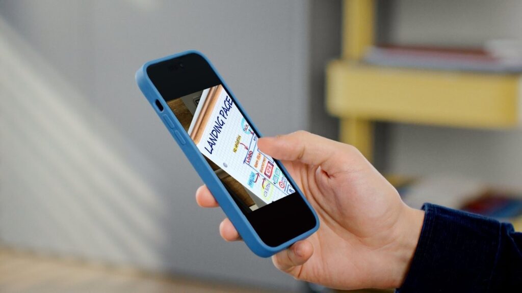 スマートフォンで「Landing Page」と書かれた画像を確認している人の手。