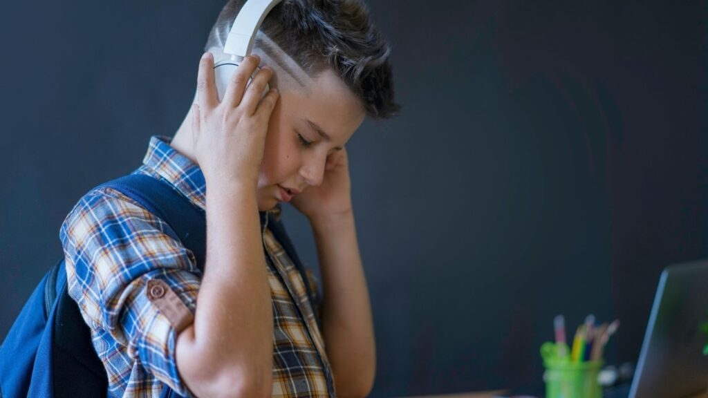 ヘッドホンをつけている若い男の子のクローズアップ。